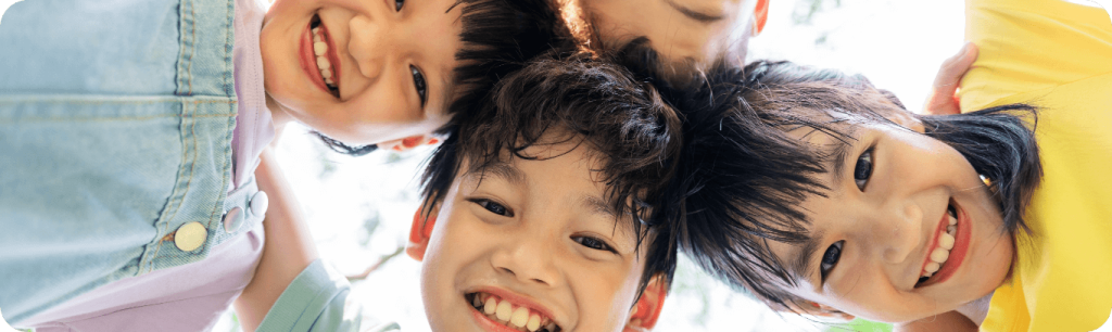 Four children smiling in a circle